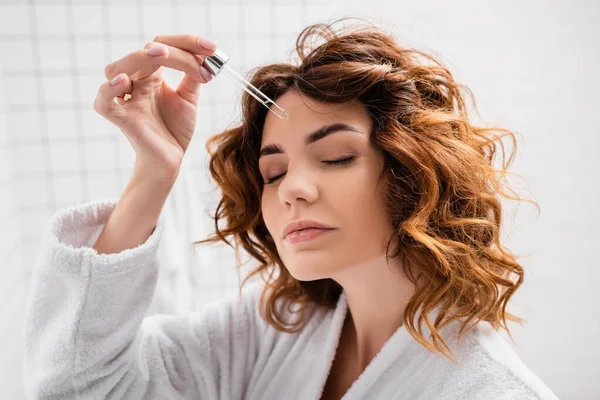 Mulher Encaracolada Aplicando Soro Cosmético Banheiro — Fotografia de Stock