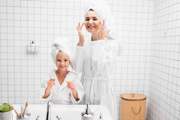 Sorrindo Mãe Criança Aplicando Creme Facial Banheiro — Fotografia de Stock