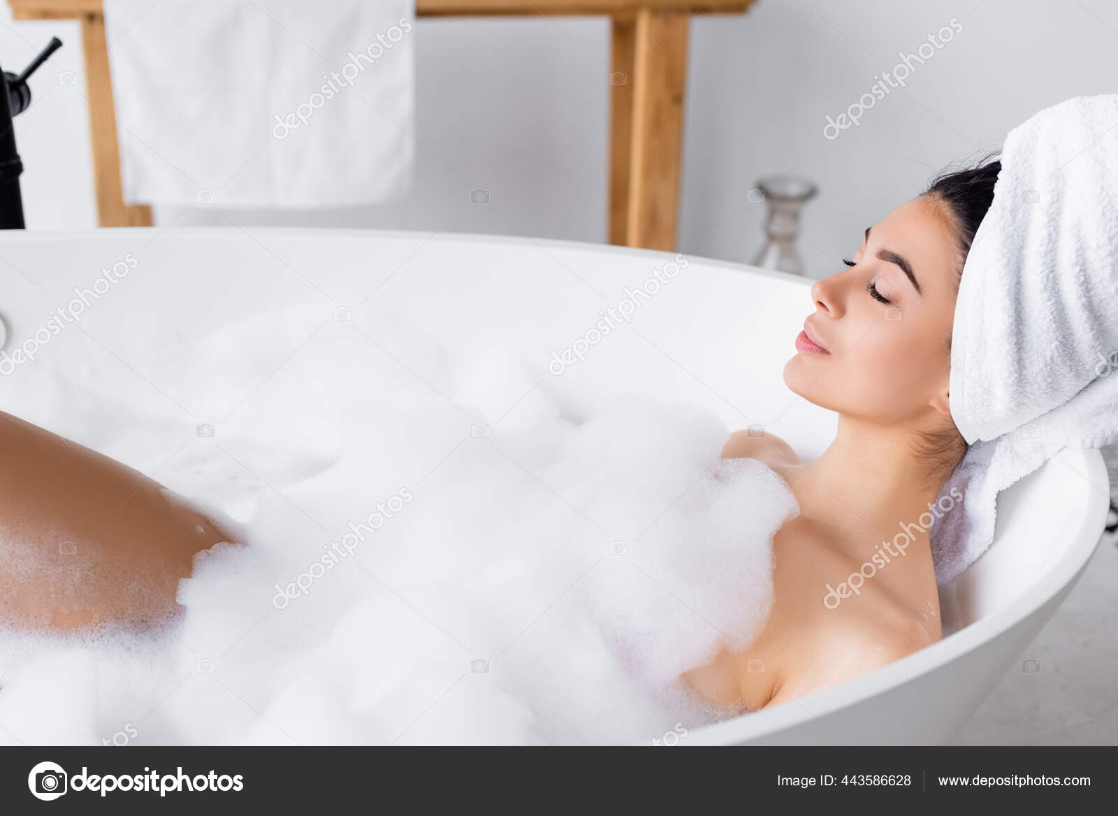 Mujer con toalla en la cabeza saliendo de la ducha con un reloj Fotografía  de stock - Alamy