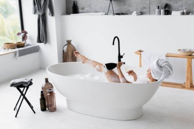 Şampanyalı kadın modern banyoda banyo yapıyor. 