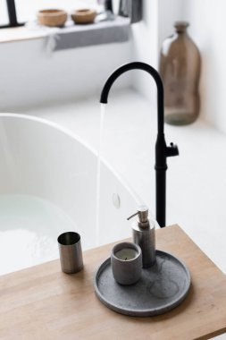 Mumlar ve tuvalet malzemeleri bulanık arka planda musluğun yanındaki banyo tepsisinde. 