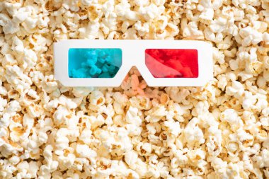 top view of 3d glasses on crunchy popcorn, cinema concept clipart