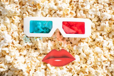 top view of 3d glasses near paper cut lips on tasty popcorn, cinema concept clipart