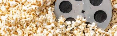 Havalı, lezzetli patlamış mısır, pankart, sinema konsepti üzerine film makarasının üst görüntüsü