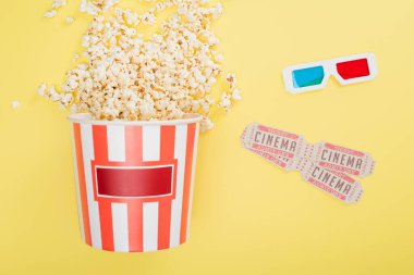 Patlamış mısırlı kova manzarası, 3D gözlükler ve sarı sinema biletleri.