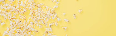 top view of salty tasty popcorn on yellow, banner, cinema concept clipart