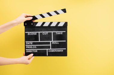 Kamera asistanının el çırpma tahtasını tutuş şekli sarı, sinema konseptine izole edilmiş