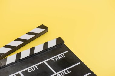 close up view of clapperboard on yellow background, cinema concept clipart