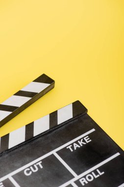 close up view of clapperboard on yellow, cinema concept clipart