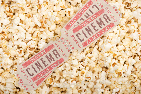 top view of cinema tickets on airy crispy popcorn 