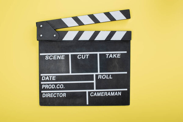 top view of clapperboard on yellow, cinema concept