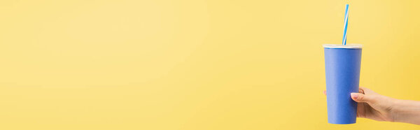 обрезанный вид женщины, держащей чашку соды изолированы на желтый, баннер