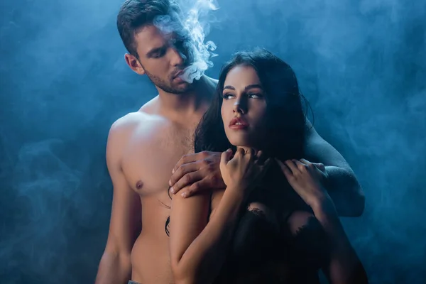 Sexy Hombre Fumando Abrazando Novia Sujetador Sobre Fondo Negro Con —  Fotos de Stock