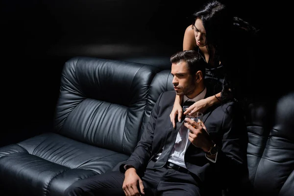 Man Holding Glass Whiskey Seductive Woman Couch Isolated Black — Stock Photo, Image