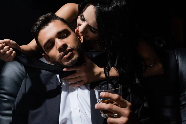 Sexy Mujer Mordiendo Oreja Novio Con Whisky Aislado Negro — Foto de Stock