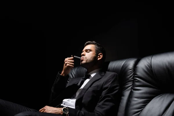 Hombre Traje Sosteniendo Encendedor Cerca Cigarrillo Sofá Aislado Negro —  Fotos de Stock