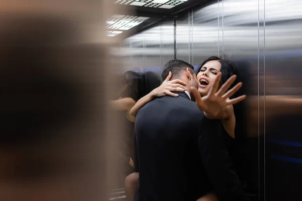 Young sexy couple making love in elevator on blurred foreground
