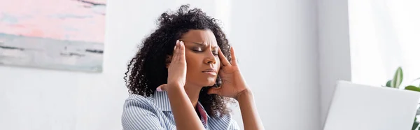 Afroamerykanka Cierpiąca Ból Głowy Pobliżu Laptopa Niewyraźnym Pierwszym Planie Baner — Zdjęcie stockowe