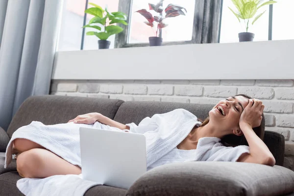 Tertawa Wanita Muda Dengan Mata Tertutup Beristirahat Sofa Dekat Laptop — Stok Foto