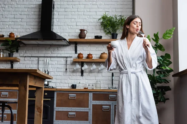 Playful Young Adult Woman White Bathrobe Holding Cup Coffee Spatula Royalty Free Stock Photos