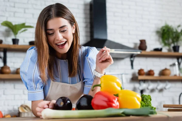 Mujer Adulta Joven Positiva Mirando Verduras Frescas Mesa Cocina Fotos de stock libres de derechos