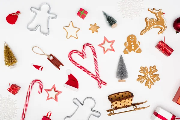 Vue du haut des cannes à bonbons et des différents biscuits près des boules de Noël sur fond blanc — Photo de stock