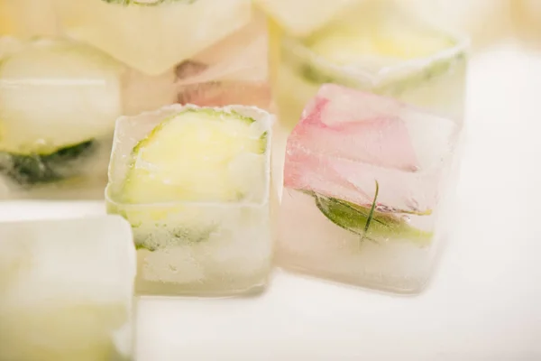 Vista de perto de refrescante cubos de gelo vegetal no fundo branco desfocado — Fotografia de Stock