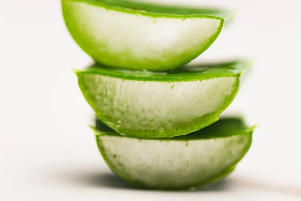 Vista de perto de cortar folhas de aloe vera na superfície branca — Fotografia de Stock