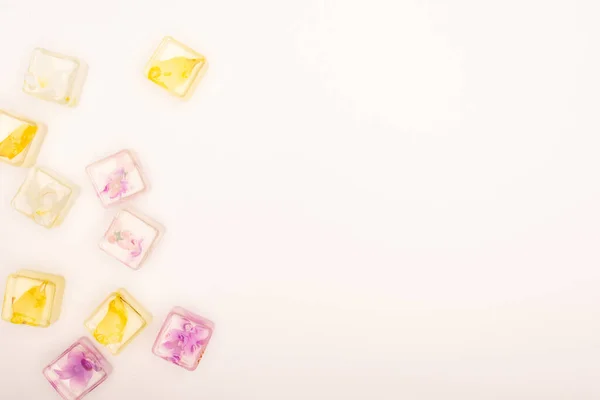 Вид сверху на цветочные и фруктовые освежающие кубики льда на белом фоне с копировальным пространством — стоковое фото