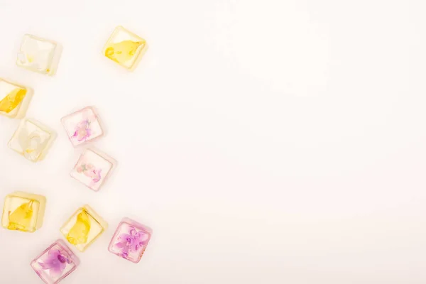 Vista dall'alto di cubetti di ghiaccio rinfrescanti floreali e frutta su sfondo bianco con spazio per la copia — Foto stock