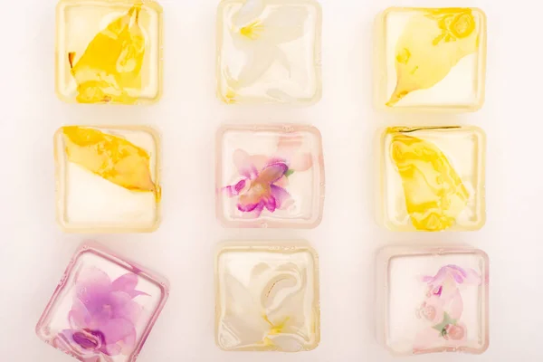 Vue de dessus des fruits congelés et des glaçons floraux sur fond blanc — Photo de stock