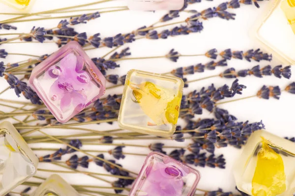 Draufsicht auf Blumen- und Fruchteiswürfel und Lavendelzweige auf weißer Oberfläche — Stockfoto