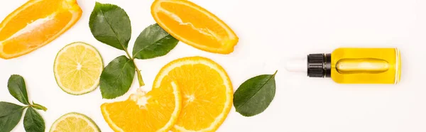 Vue du dessus des tranches d'orange et des feuilles de rose près de la bouteille avec de l'essence d'agrumes sur blanc, bannière — Photo de stock