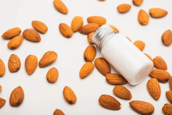 Almonds and fresh homemade almond milk in bottle on white surface — Stock Photo