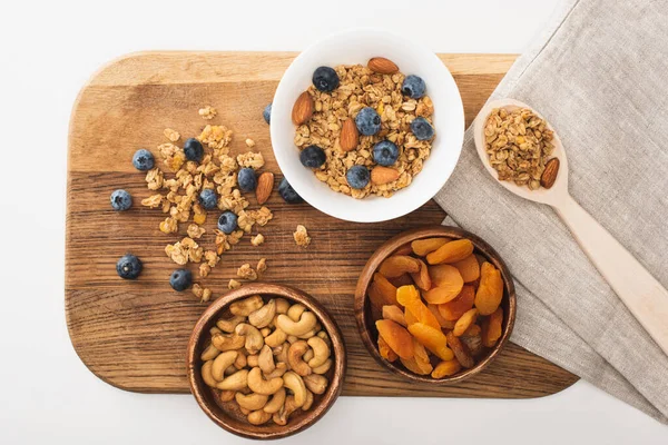 Vista superior de granola deliciosa com nozes, mirtilo e damascos secos isolados em branco — Fotografia de Stock