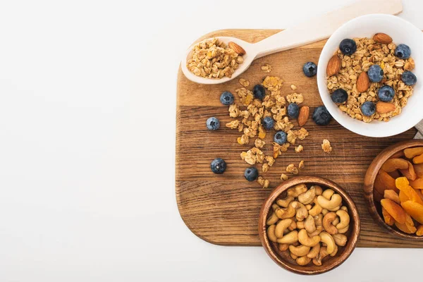 Blick von oben auf köstliches Müsli mit Nüssen, Blaubeeren und getrockneten Aprikosen isoliert auf weiß — Stockfoto