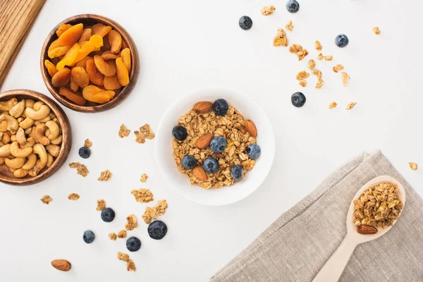 Blick von oben auf köstliches Müsli mit Nüssen, Blaubeeren und getrockneten Aprikosen isoliert auf weiß — Stockfoto