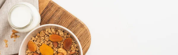 Top view of delicious granola with nuts, yogurt and dried apricots isolated on white, banner — Stock Photo