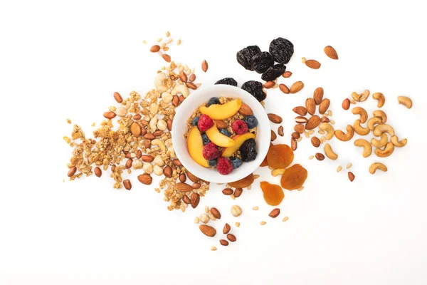 Вид сверху на вкусную гранолу с орехами и фруктами, разбросанными по чашам — стоковое фото