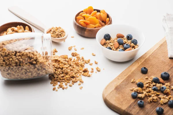 Délicieux granola aux noix, abricots secs et bleuets sur fond blanc — Photo de stock