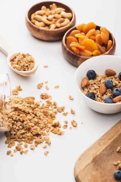 Délicieux granola aux noix, abricots secs et bleuets sur fond blanc — Photo de stock