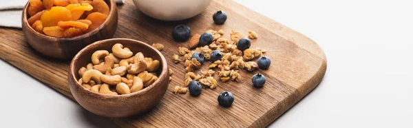 Köstliches Müsli mit Nüssen, getrockneten Aprikosen und Blaubeeren auf weißem Hintergrund, Banner — Stockfoto