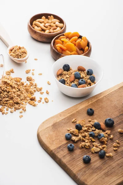 Köstliches Müsli mit Nüssen, getrockneten Aprikosen und Blaubeeren auf weißem Hintergrund — Stockfoto