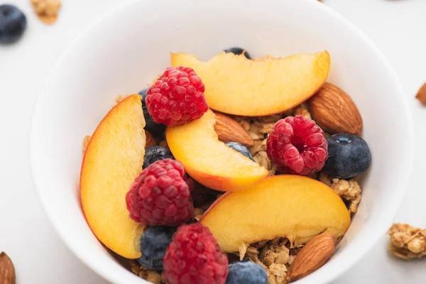 Closeup of delicious granola with nuts, peach, blueberry and raspberry — Stock Photo