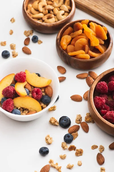 Deliciosa granola com nozes e frutas no fundo branco — Fotografia de Stock