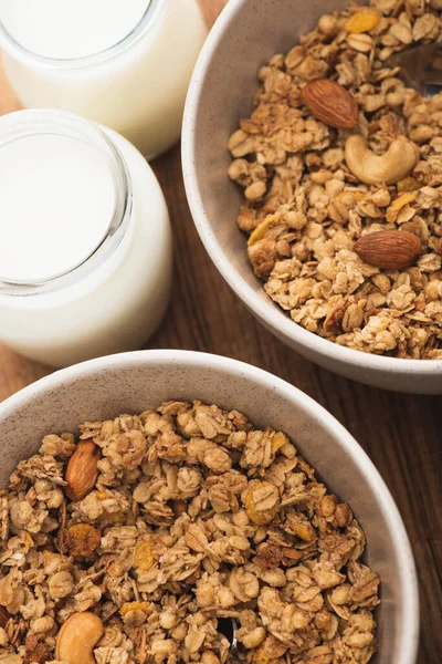 Close-up de granola deliciosa com nozes e iogurte em tábua de madeira — Fotografia de Stock