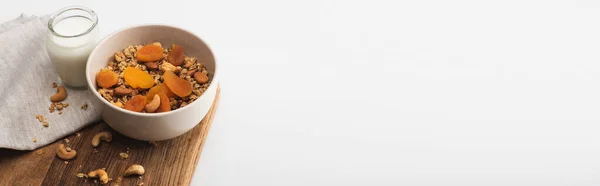 Deliciosa granola com nozes, damascos secos e iogurte em placa de madeira no fundo branco, banner — Fotografia de Stock