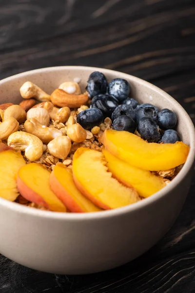 Delicious granola with nuts, peach, blueberry in bowl — Stock Photo