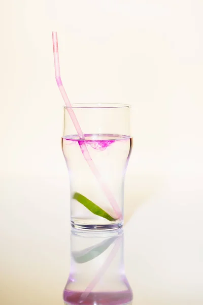 Verre à la chaux dans une boisson alcoolisée avec sirop violet sur blanc — Photo de stock