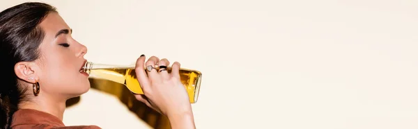 Vista laterale della donna bruna che beve birra sul bianco, banner — Foto stock